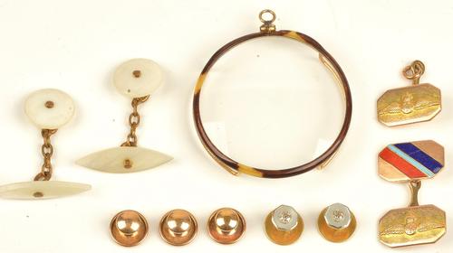 A pair of gold, diamond and mother-of-pearl dress studs, each mounted with a cushion shaped diamond to the centre, on a mother-of-pearl ground,...