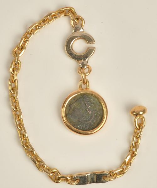 A gold key chain of oval link design, with a pendant mounted coin as fitted, the fastening clasp detailed 750, gross weight 15.2gms.