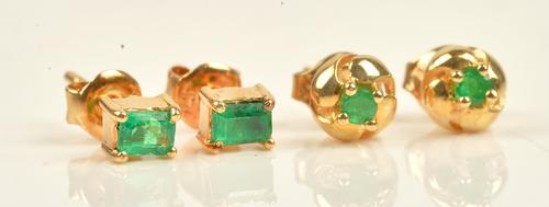 A pair of gold and emerald single stone ear studs, each claw set with a cut cornered rectangular step cut emerald, the backs with post and butterfly...