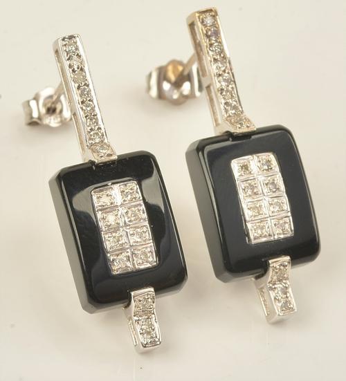 A pair of 18ct white gold, diamond and black onyx earrings, each with a rectangular black onyx panel, centred by eight circular cut diamonds, the...