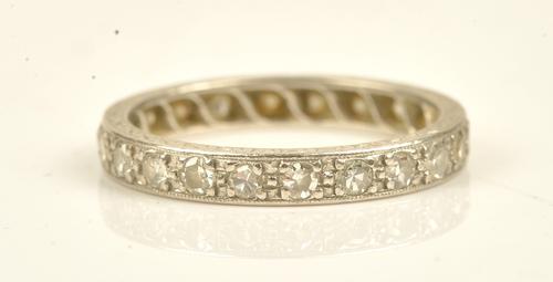 A platinum and diamond set full eternity ring mounted with circular cut diamonds, the sides of the mount with engraved decoration, detailed PT, ring...