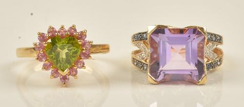 An 18ct gold, peridot and pink sapphire set heart shaped cluster ring, claw set with a heart shaped peridot at the centre, in a surround of circular...