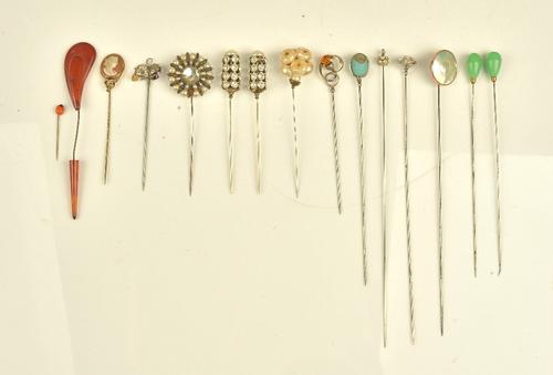 A collection of fifteen hat and stick pins including, a shell cameo, two thistles and two pairs of hat pins, one with pale green glass terminals and...