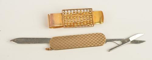 A gold money clip, designed as an abacus, detailed 14 K, weight 16.5 gms and a gold mounted folding pocket knife cum nail file cum pair of scissors,...