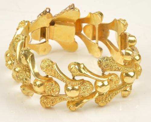 A gold bracelet in a decorated V shaped link design, on a snap clasp, apparently unmarked, gross weight 65 gms.