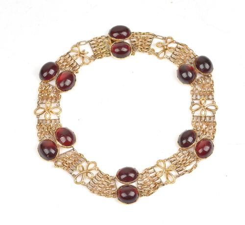 A gold and carbuncle garnet collar necklace, of reconstructed form, mounted with six pairs of foil backed oval carbuncle garnets, connected by...