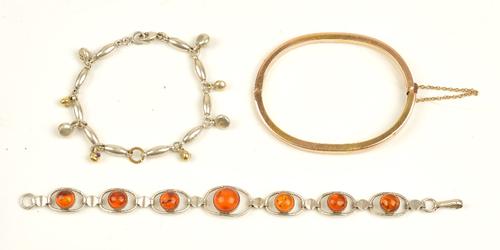 A gold oval hinged bangle, on a snap clasp, gross weight 10.2 gms, a reconstituted amber bracelet and a silver baton shaped link bracelet, with...
