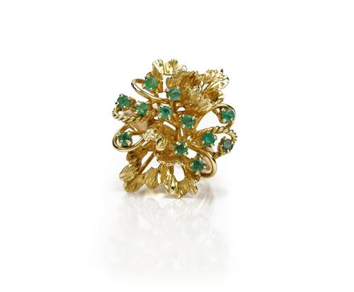 A gold and emerald ring, in an abstract design, claw set with twelve small circular cut emeralds, detailed 14 K, ring size R, gross weight 7.9 gms,...