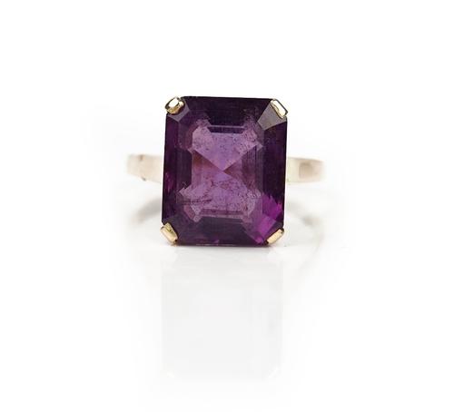 A gold ring, claw set with a cut cornered rectangular step cut amethyst, detailed indistinctly 14 K, ring size S and a half, gross weight 7.3 gms,...