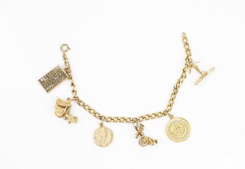 A faceted curb link charm bracelet, detailed 333, fitted with six pendants and charms including; a thistle, an abacus and a rickshaw, weight 25.2 gms.