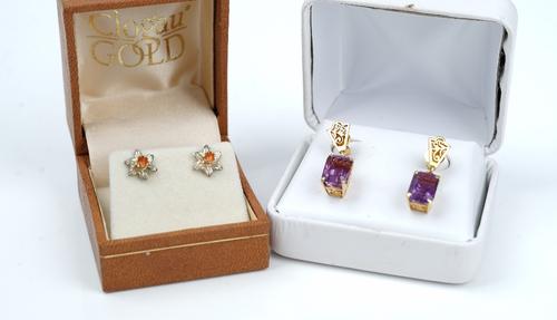 A pair of gold and amethyst single stone pendant earrings, each drop claw set with a cut cornered rectangular step cut amethyst, otherwise with...