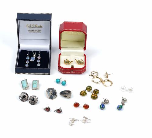 A pair of gold, emerald and diamond earstuds, each of scrolled design, mounted with three circular cut emeralds and with two circular cut diamonds,...