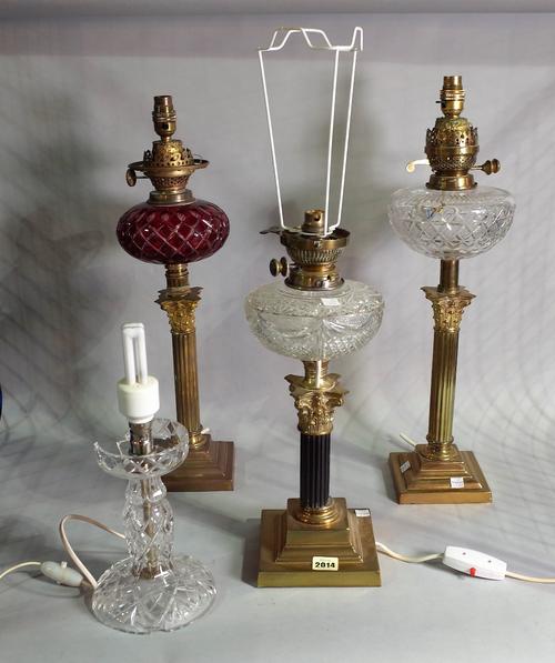 A group of three early 20th century brass oil lamps, later converted to electricity, each on acanthus columns with cut glass decoration, 60cm high,...