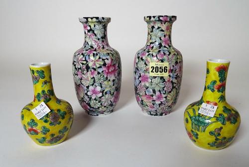 A pair of Chinese baluster vases, painted with flowers against a black ground, 17cm high, and a pair of yellow ground Chinese vases, 12cm high, (4).