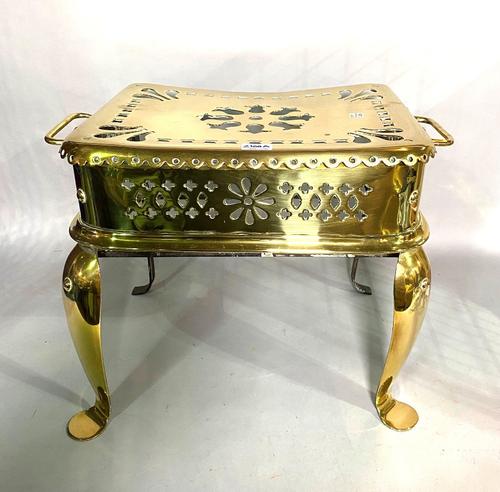 An early 19th century twin handled brass footman/trivet with pierced decoration and cabriole legs, 48cm wide x 35cm high.