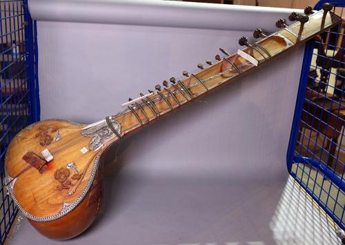 A late 19th/ early 20th century eastern bone inlaid Sitar, the sound box formed from a carved gourd, 140cm long, (a.f.).