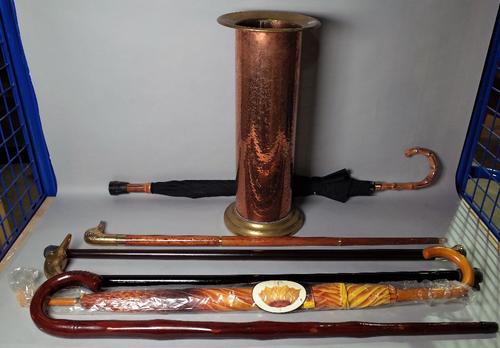 An early 20th century brass stick stand, 48cm high, and a group of four modern walking canes and two umbrellas, (7).