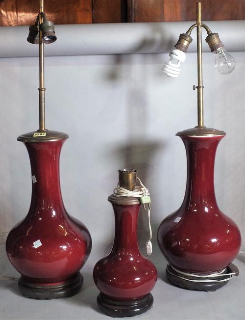 A pair of modern Chinese Sang De Beouf vases, later converted to lamps, 80cm high, and another smaller, 36cm high, (3).