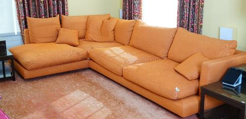 A contemporary Long Island sectional sofa, in three parts, upholstered in orange woven fabric, with loose back and seat cushions and three scatter...