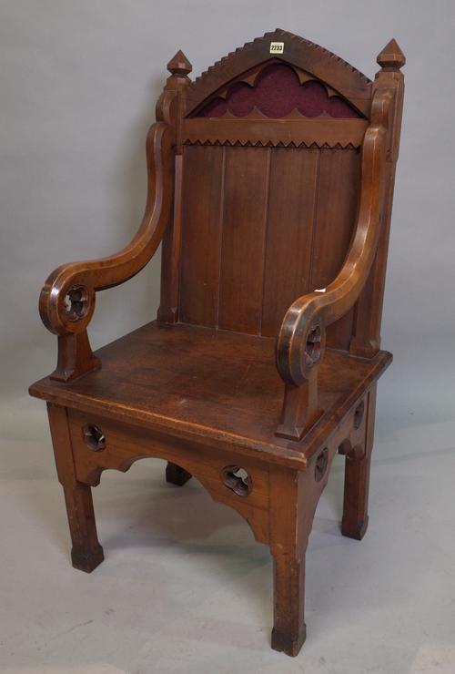 An early 20th century pitch pine Gothic revival open armchair, 62cm wide x 155cm high.