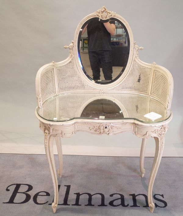A Victorian style white painted dressing table, with oval mirror and canework decoration, 92cm wide x 140cm high.