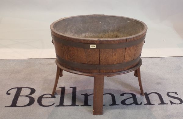 A George III style oval oak brass bound open wine cooler, lead lined, on splayed legs, 63cm wide x 53.5cm high.