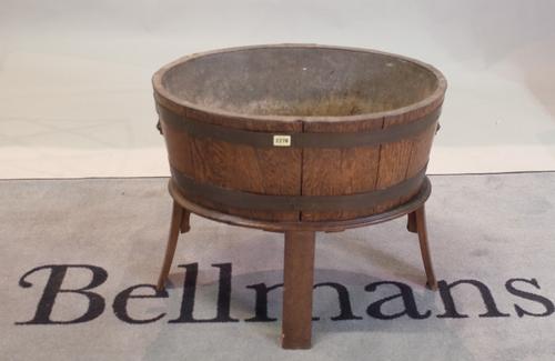 A George III style oval oak brass bound open wine cooler, lead lined, on splayed legs, 63cm wide x 53.5cm high.