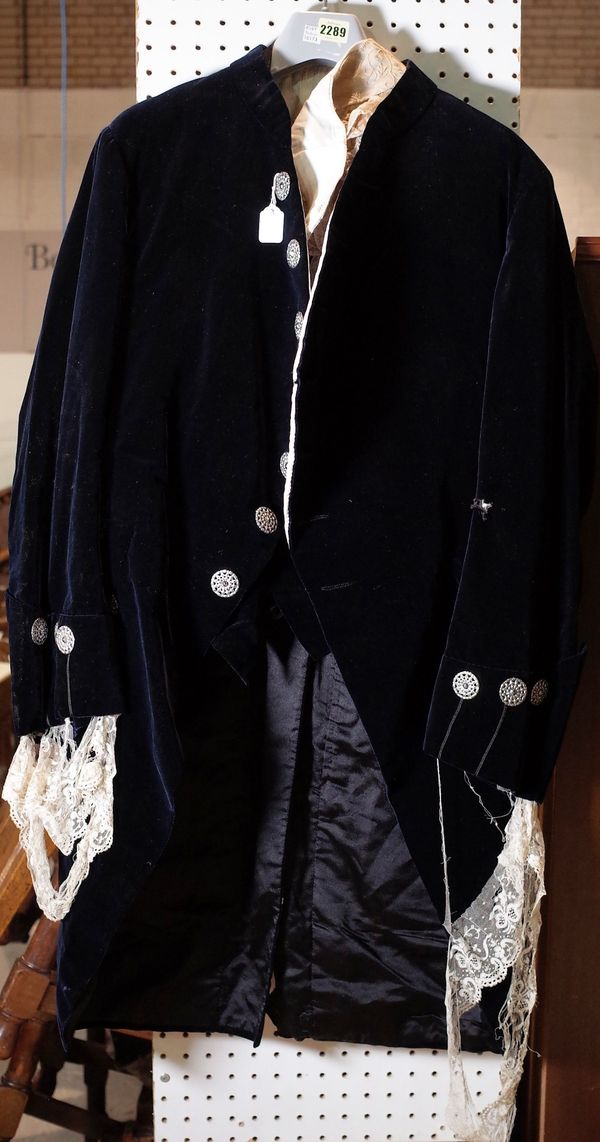 An 18th century style velvet costume, comprising; a waistcoat, jacket, trousers, a pair of gloves, shoes and stockings.