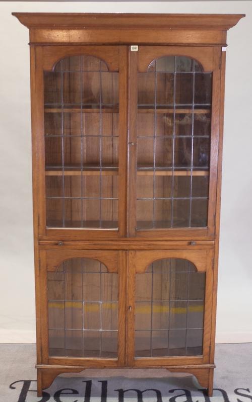 An early 20th century oak floor standing display cabinet, with lead glazed doors, on bracket feet, 105cm wide x 191cm high.