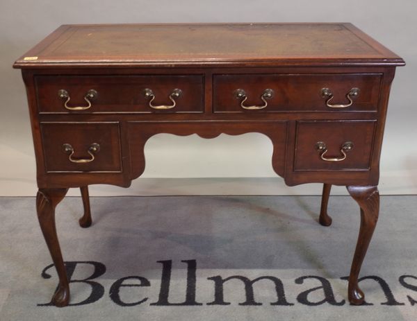 A George II style mahogany kneehole writing desk, on cabriole supports, 98cm wide x 77cm high.