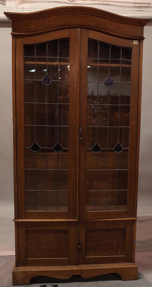 An early 20th century oak floor standing bookcase with lead lined glazed doors, over cupboard base, 100cm wide x 198cm high.