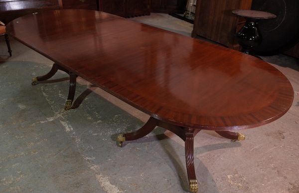 A George III style mahogany twin pillar dining table, on outswept supports, 306cm wide x 78cm high.