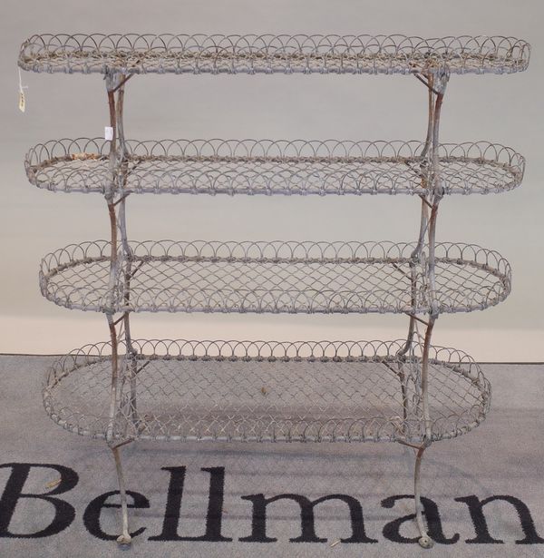 A late Victorian wirework graduated four-tier conservatory plant stand, rectangular with rounded ends, on splayed legs, 91cm wide x 92cm high.