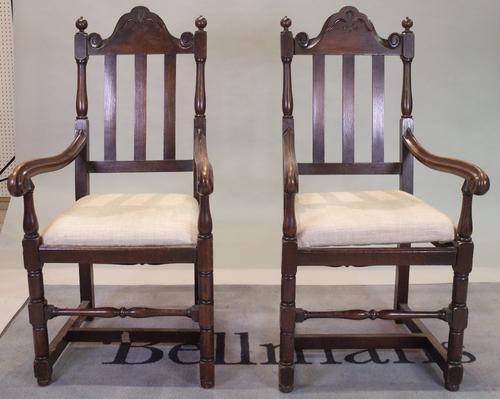 A pair of 18th century style oak high back open armchairs, 53cm wide x 116cm high.