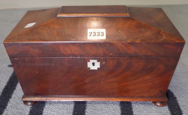 A Regency mahogany tea caddy of sarcophagus form on bun feet, 31cm wide x 19cm high.