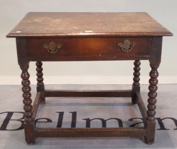 An 18th century oak single drawer low side table on bobbin turned supports, 77cm wide x 63cm high.