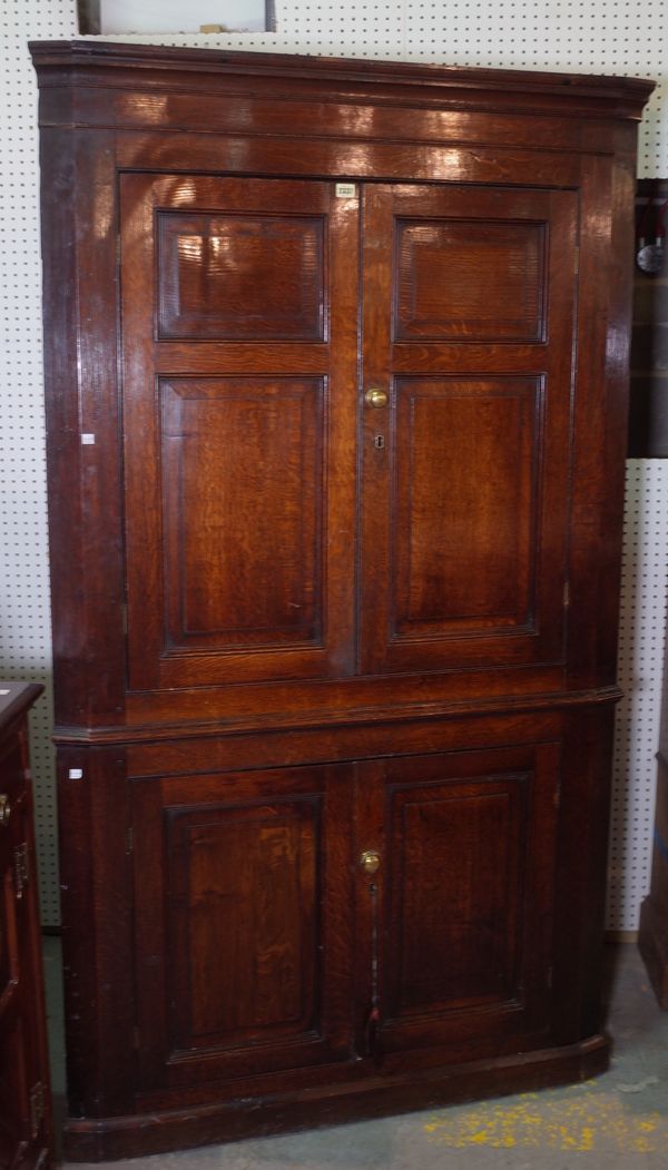 A late 18th century oak floor standing corner cupboard with panelled doors, 111cm wide x 198cm high.