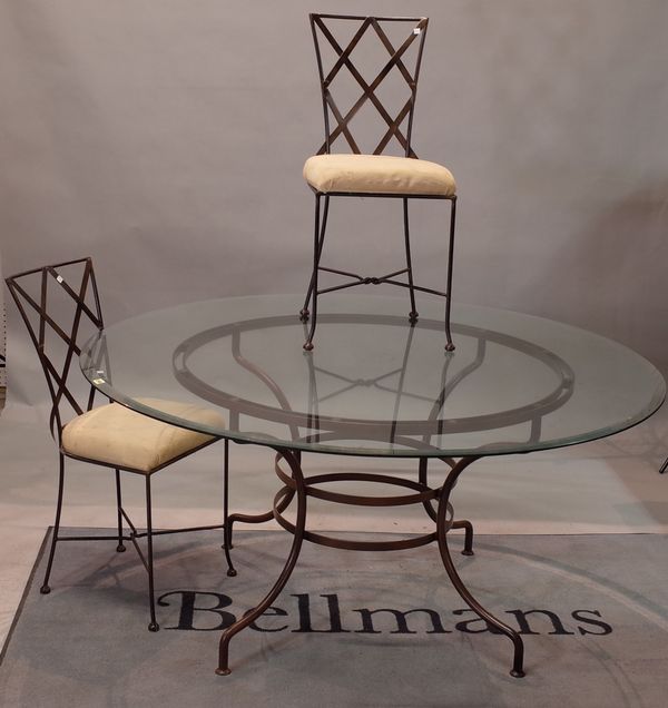 A circular metal and glass dining table, 230cm diameter,  together with six metal chairs with lattice backs, 40cm wide x 93cm high.