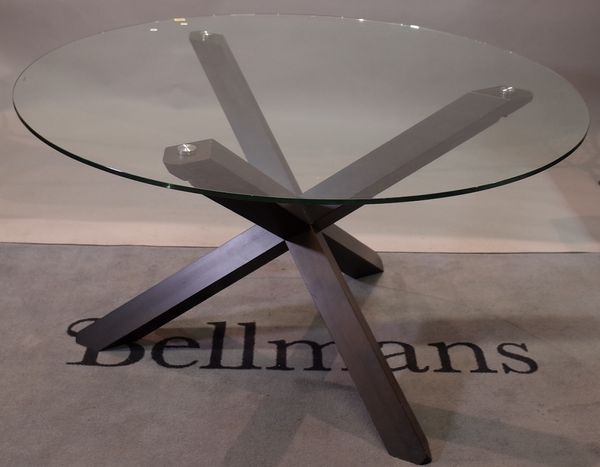 A glass circular dining table, on a stained beech 'X' frame base, 130cm diameter x 77cm high.