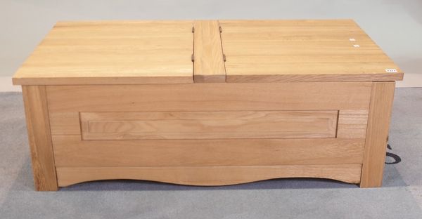 An oak lift top coffee table on block supports, 115cm wide x 42cm high.