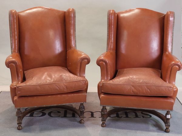 A pair of late 17th century Flemish style mahogany framed wingback armchairs on turned supports, united by an 'X' frame stretcher, 76cm wide x 104cm...