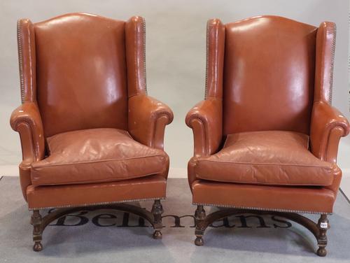 A pair of late 17th century Flemish style mahogany framed wingback armchairs on turned supports, united by an 'X' frame stretcher, 76cm wide x 104cm...