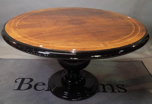 A modern circular walnut and ebonised lacquer dining table on baluster turned column base, 135cm diameter.