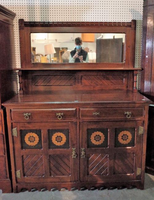 An early 20th century Aesthetic Movement mirrored back sideboard with two short drawers over a cupboard base, 136cm wide x 174cm high.