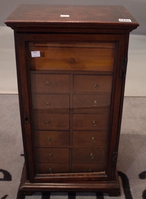 A Victorian mahogany table top specimen cabinet, fitted with an arrangement of fourteen drawers, enclosed by a glazed door, 34cm wide x 62cm high.