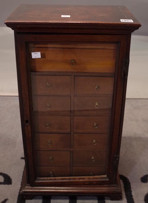 A Victorian mahogany table top specimen cabinet, fitted with an arrangement of fourteen drawers, enclosed by a glazed door, 34cm wide x 62cm high.
