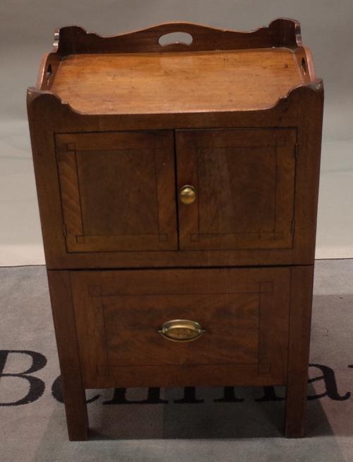 Two similar George III mahogany tray top night commodes, each enclosed by a pair of doors with a pull-out slide below, one boxwood strung, one ebony...