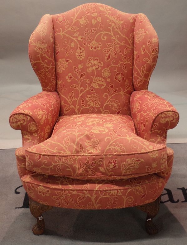 A George I style wingback armchair, on leafy scroll carved cabriole legs, 87cm wide x 105cm high.