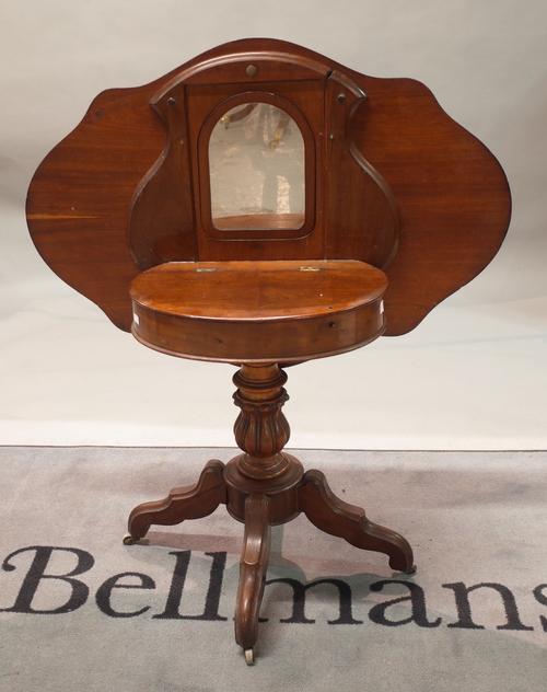 A Dutch mahogany and walnut combined centre table and dressing table, circa 1840, the serpentine outline tilt-top enclosing a mirror and compartment,...
