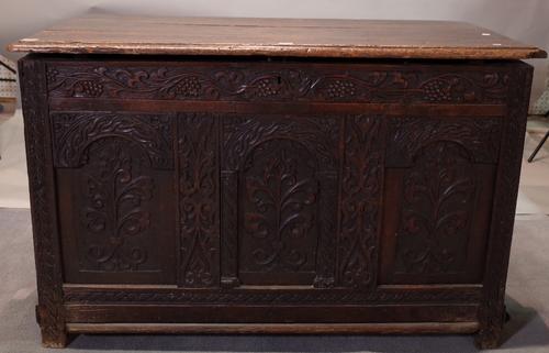 A 17th century oak coffer, the plank top over triple panel front, 120cm wide x 75cm high.